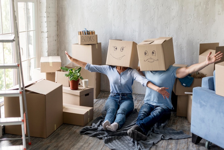 couple-home-moving-day-with-boxes-heads_23-2148647482